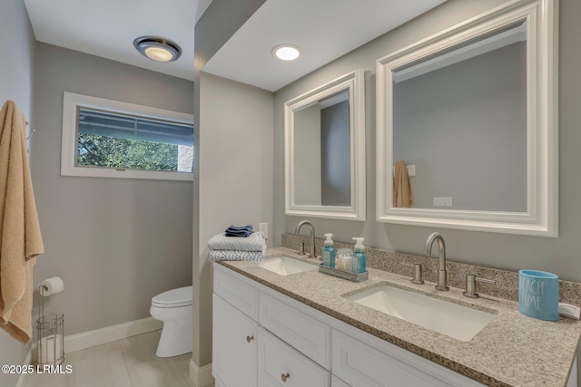 bathroom with tile patterned flooring, vanity, and toilet