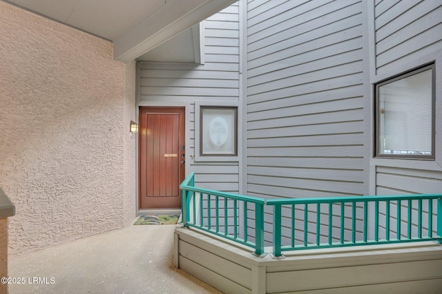 view of exterior entry with a balcony