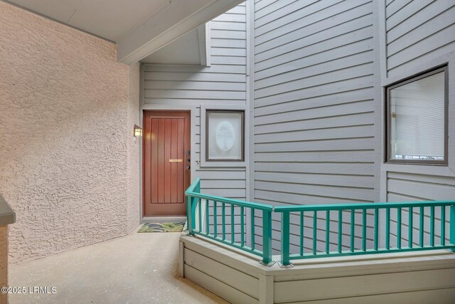 view of exterior entry with a balcony