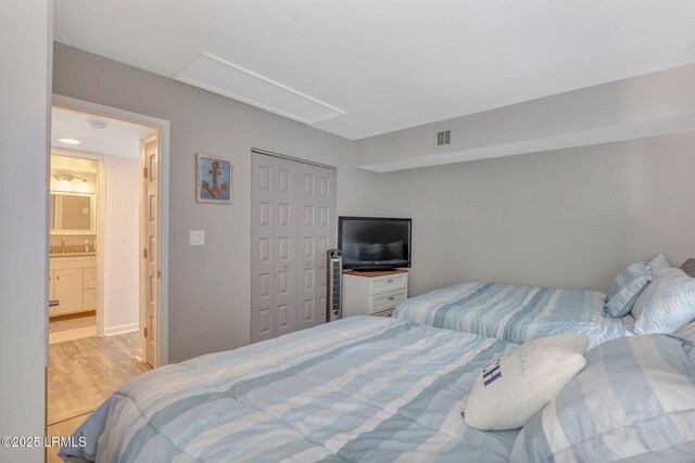 bedroom with light hardwood / wood-style floors and a closet