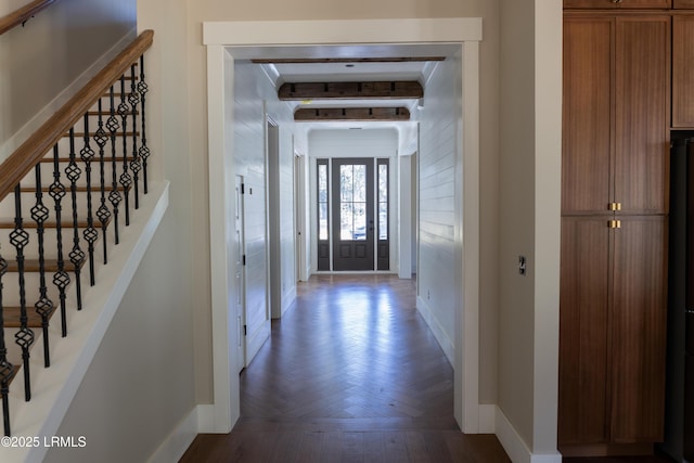 foyer with beam ceiling and dark parquet floors