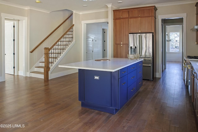 kitchen featuring dark wood-type flooring, blue cabinetry, a center island, ornamental molding, and high end refrigerator