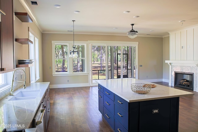 kitchen featuring light stone counters, sink, plenty of natural light, and a kitchen island