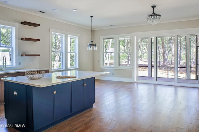 kitchen featuring decorative light fixtures, plenty of natural light, and blue cabinetry