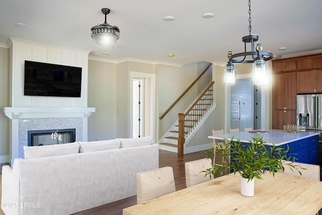 dining area with crown molding, dark hardwood / wood-style floors, and a tile fireplace