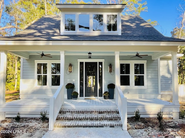 view of exterior entry featuring a porch and ceiling fan