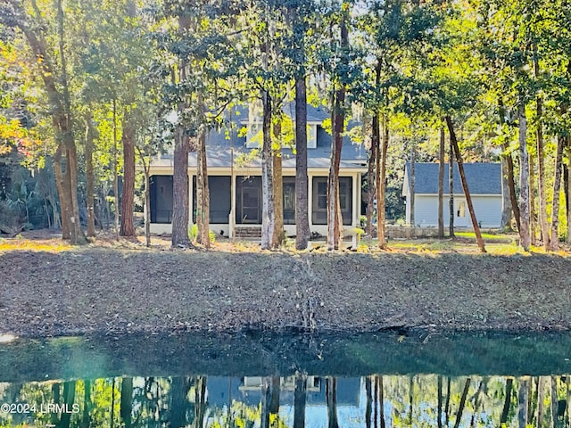 rear view of property featuring a water view and a sunroom