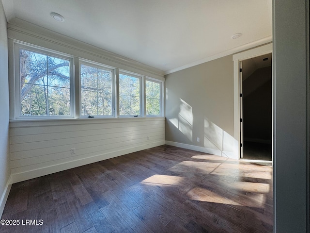 empty room with crown molding and dark wood-type flooring