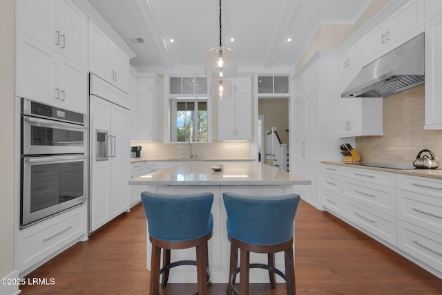 18 Baynard Cove Rd, Hilton Head Island, SC 29928 - kitchen with dark wood-type flooring, black electric stovetop, under cabinet range hood, beamed ceiling, and double oven