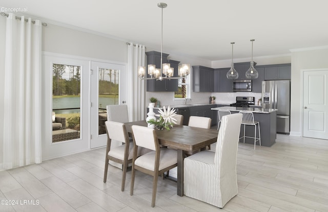 dining area featuring ornamental molding, light hardwood / wood-style floors, and a chandelier