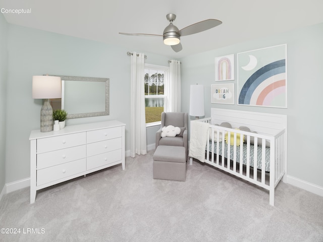 bedroom featuring a nursery area, light colored carpet, and ceiling fan