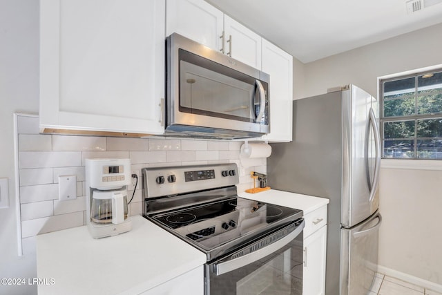 kitchen with white cabinetry, appliances with stainless steel finishes, tasteful backsplash, and light tile patterned floors