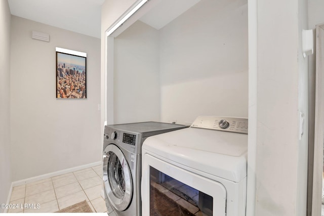 laundry area featuring light tile patterned flooring and washing machine and dryer