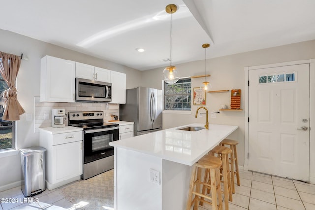 kitchen with sink, decorative light fixtures, stainless steel appliances, decorative backsplash, and white cabinets