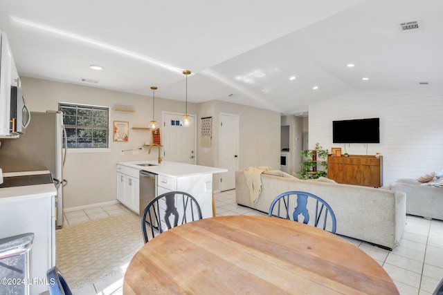 dining area with lofted ceiling, sink, and light tile patterned floors