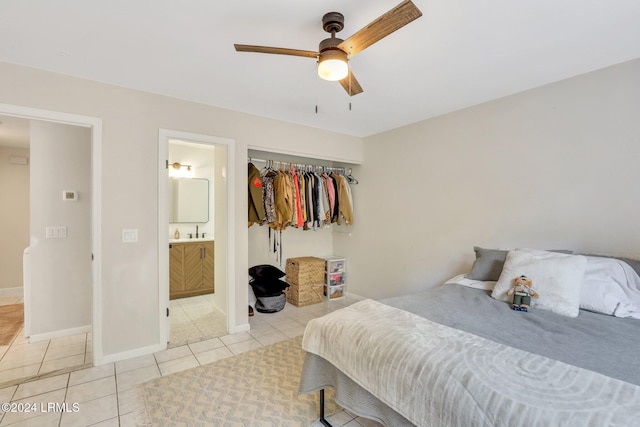 tiled bedroom with sink, ensuite bath, a closet, and ceiling fan