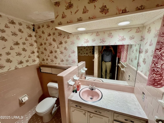 bathroom with ornamental molding, tile walls, a textured ceiling, and toilet