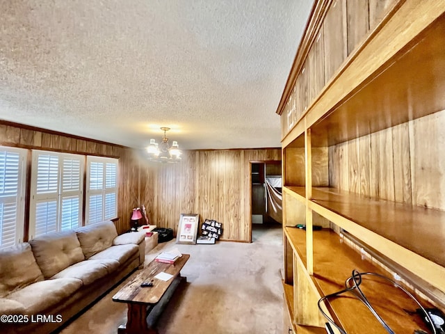 carpeted living room with an inviting chandelier and wood walls