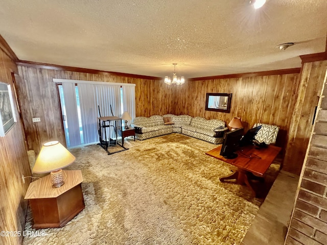 living room with carpet, a textured ceiling, an inviting chandelier, and wood walls