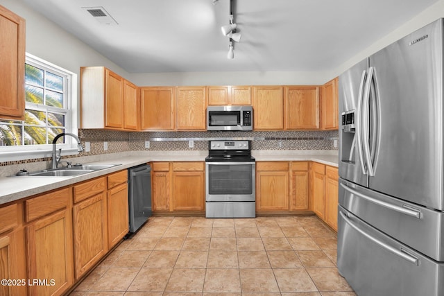 kitchen with stainless steel appliances, tasteful backsplash, sink, and light tile patterned floors