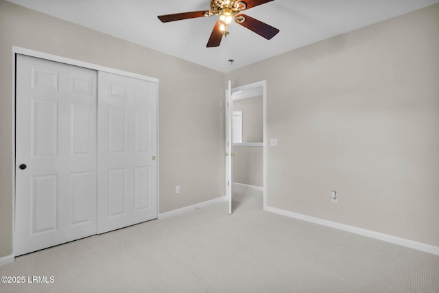 unfurnished bedroom featuring ceiling fan, light colored carpet, and a closet