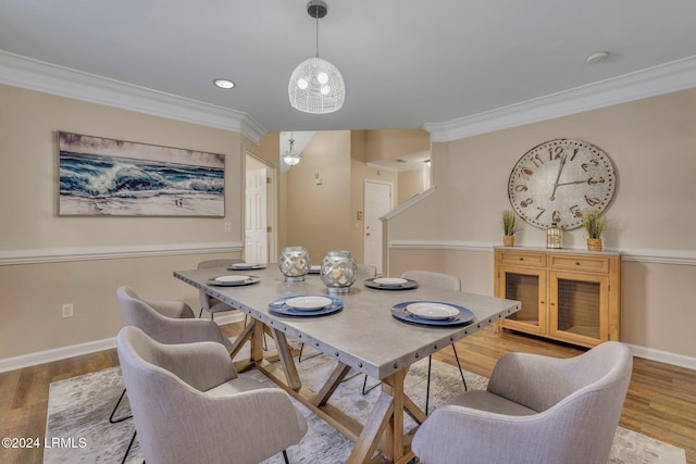 dining area with ornamental molding and light hardwood / wood-style floors