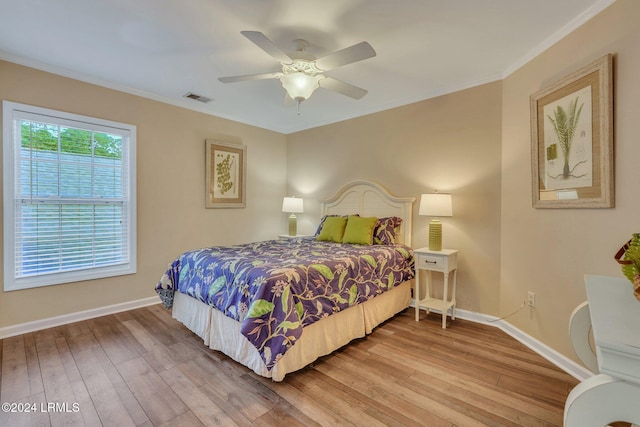 bedroom with crown molding, light hardwood / wood-style floors, and ceiling fan