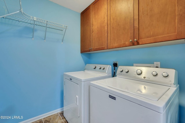 clothes washing area featuring light tile patterned floors, cabinets, and washing machine and clothes dryer