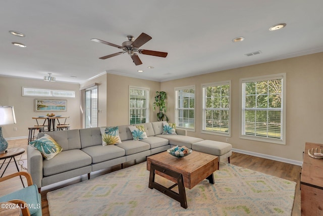 living room with crown molding and light hardwood / wood-style floors