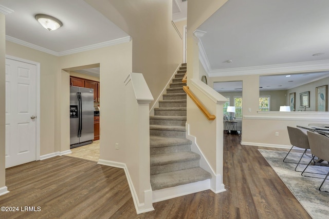 stairway featuring crown molding and hardwood / wood-style flooring