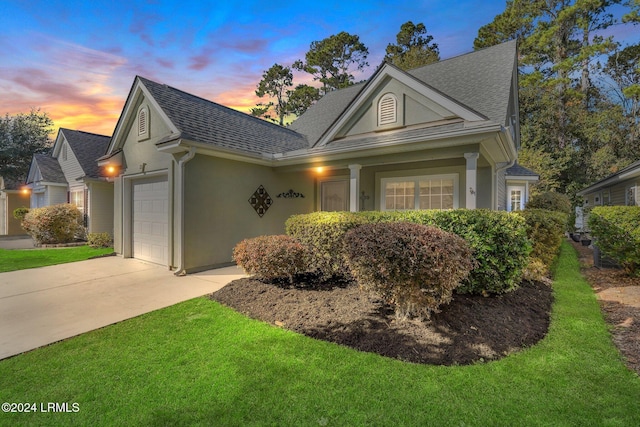 view of front of property featuring a garage and a lawn