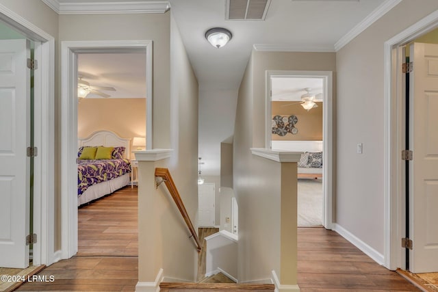 hall with ornamental molding and light hardwood / wood-style flooring