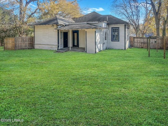 rear view of house featuring a yard