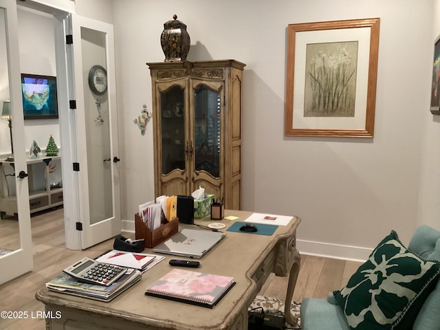 office space featuring french doors and light hardwood / wood-style flooring