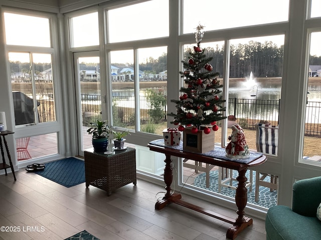 sunroom featuring a water view