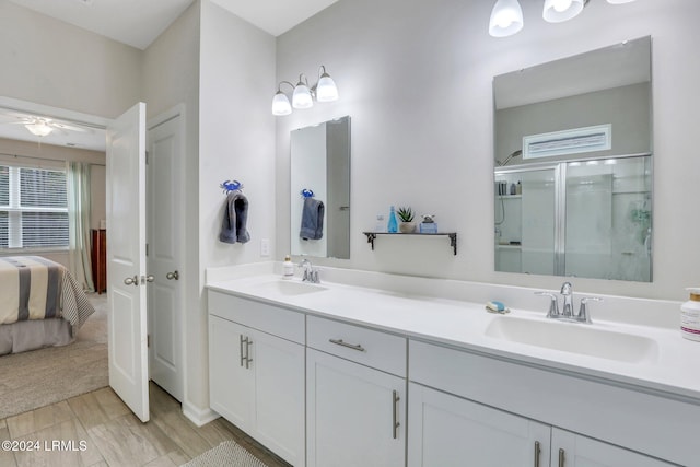 bathroom with a shower with door and vanity