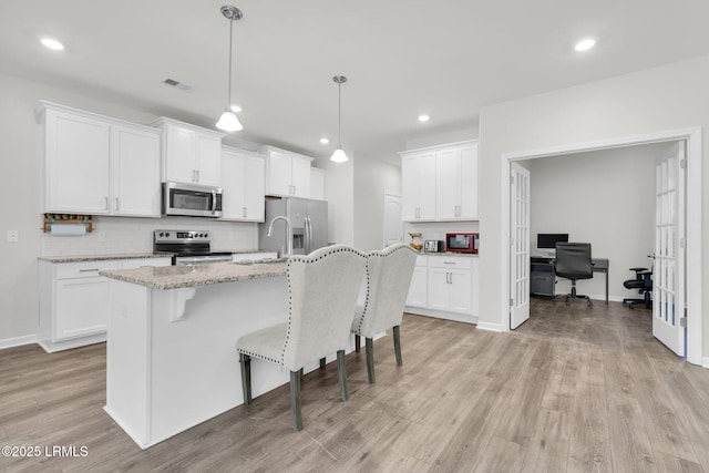 346 Sawmill Rd, Hardeeville, SC 29927 - kitchen with white cabinets, visible vents, light wood finished floors, stainless steel appliances, and a kitchen breakfast bar