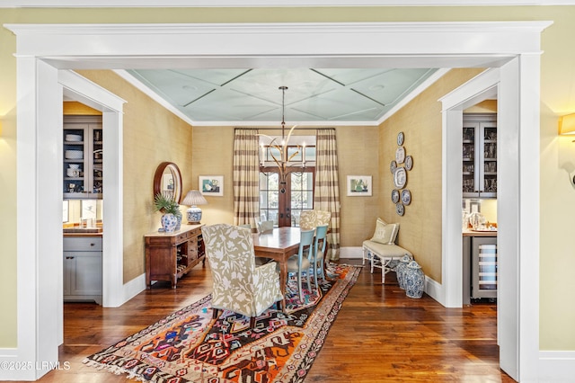 dining area featuring baseboards, wine cooler, dark wood-type flooring, crown molding, and a chandelier