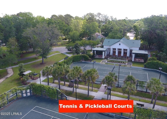 surrounding community with uncovered parking and a tennis court