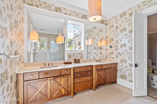 bathroom with double vanity, wallpapered walls, visible vents, baseboards, and a sink