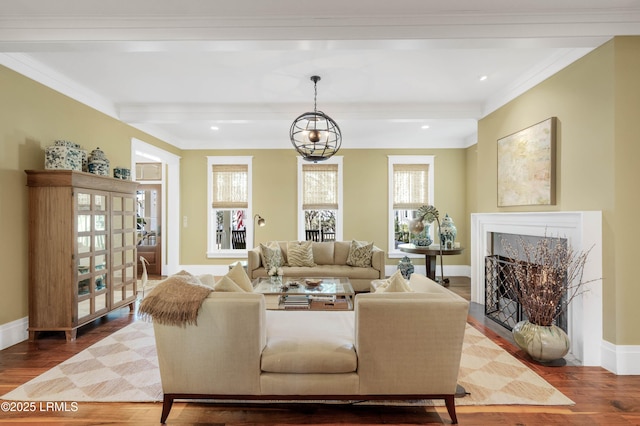 living area featuring crown molding, a high end fireplace, wood finished floors, beamed ceiling, and baseboards