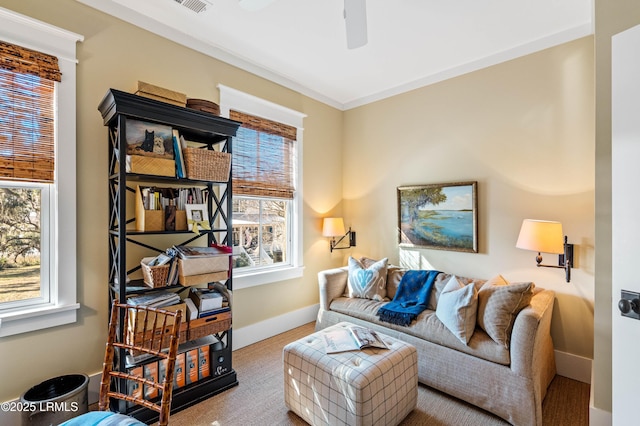 living area featuring a ceiling fan and baseboards