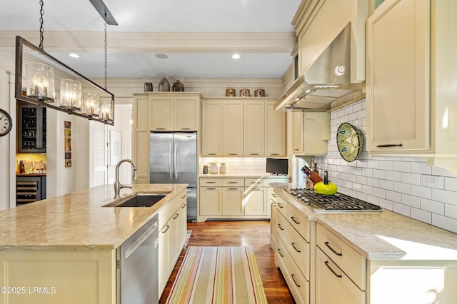 kitchen with a kitchen island with sink, stainless steel appliances, a sink, range hood, and light stone countertops