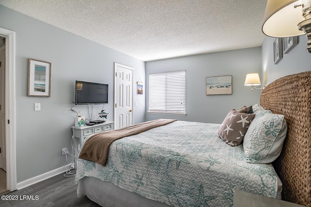 bedroom with dark wood-type flooring, a closet, and a textured ceiling