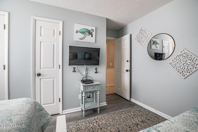 bedroom with dark hardwood / wood-style floors and a textured ceiling