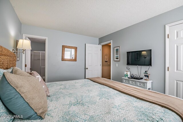 bedroom with a walk in closet, a closet, and a textured ceiling