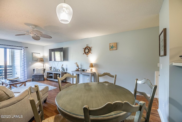 dining area with ceiling fan, hardwood / wood-style floors, and a textured ceiling