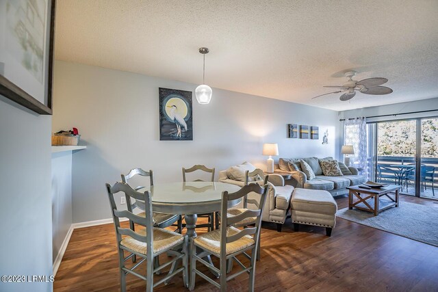 dining room featuring ceiling fan, dark wood-type flooring, and a textured ceiling