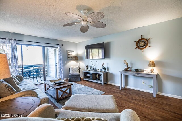 living room featuring dark hardwood / wood-style flooring, ceiling fan, and a textured ceiling