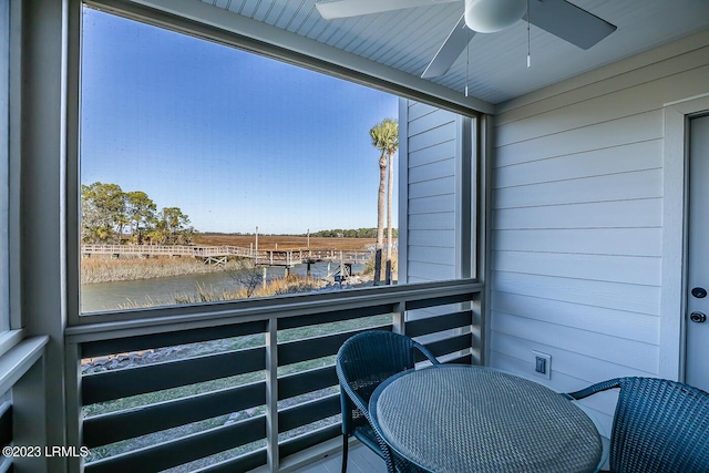 balcony with a water view and ceiling fan